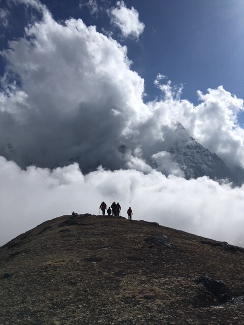 Acclimatisation walk above Chukhung with north face of Ama Dablam in background through clouds